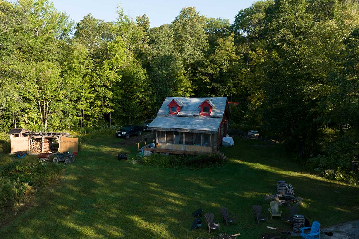 Porter Lake Retreat is a cabin surrounded by trees with two peaked red windows